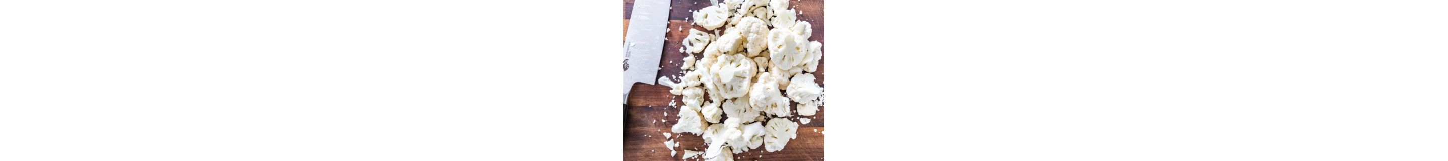 Chopped cauliflower next to a knife.