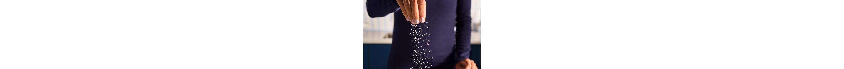 A person sprinkling salt.