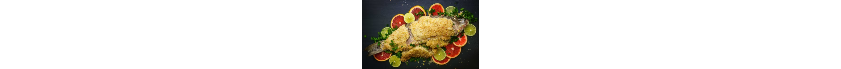 A salt-crusted whole fish on a bed of citrus fruit.