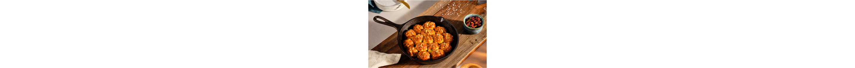 A prepared Garlic-Scallion Pretzel Pull Apart Bread in a cast-iron pan.