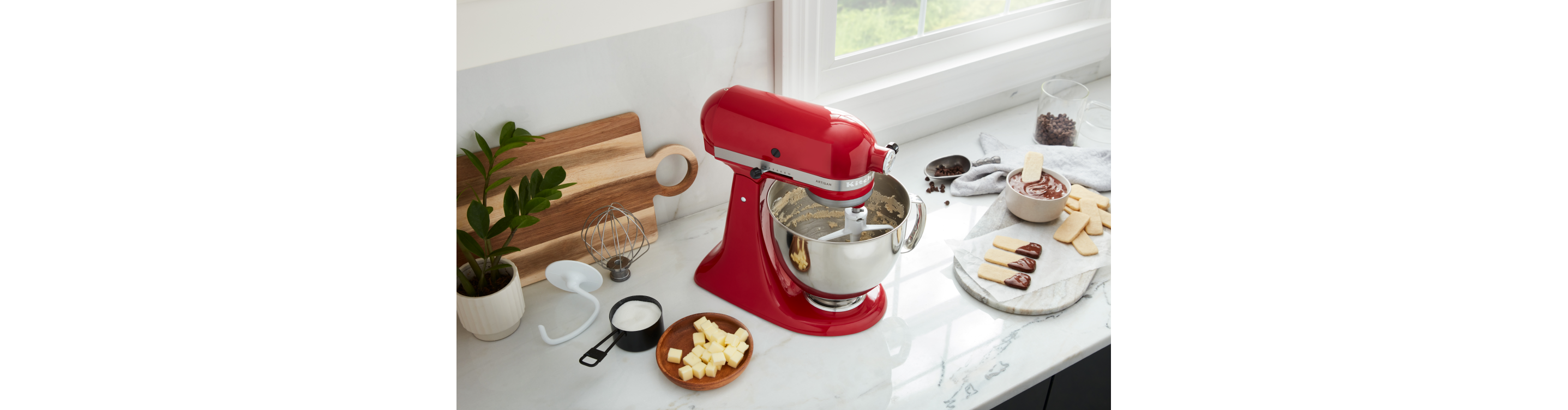 KitchenAid® Stand Mixer on a countertop surrounded by various sweet ingredients