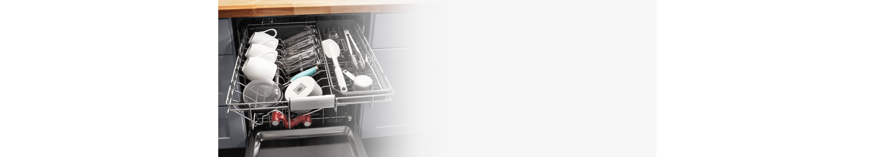 Mugs and cooking utensils in a dishwasher rack