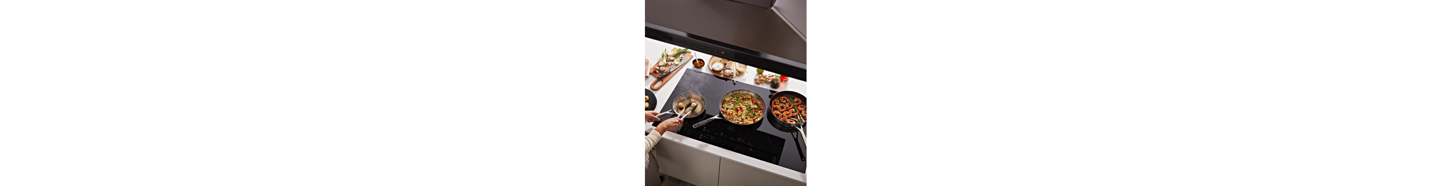 A person cooking vegetables and shrimp on cooktop