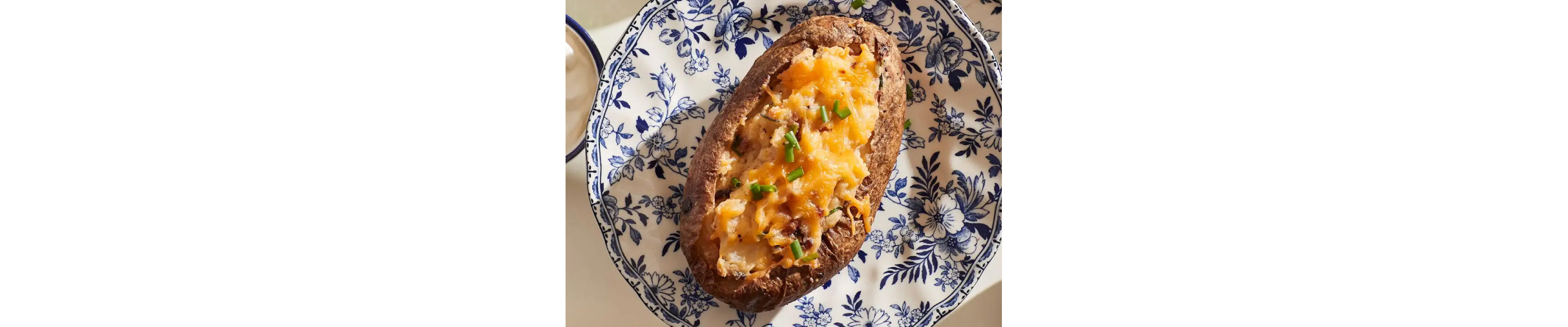 Twice baked potato on blue and white plate 
