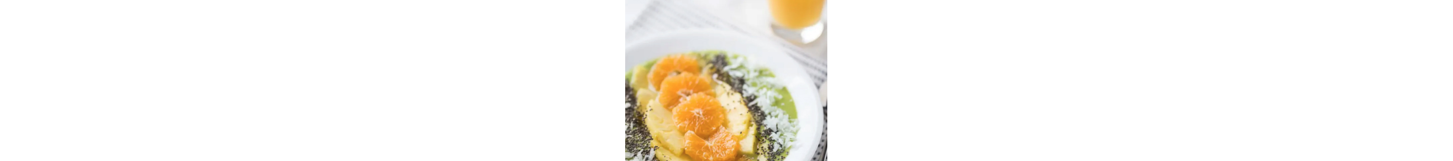 Tropical smoothie bowl topped with oranges, pineapple and shredded coconut