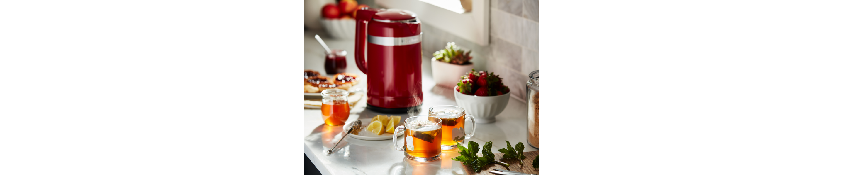 Red KitchenAid® electric kettle next to tea ingredients