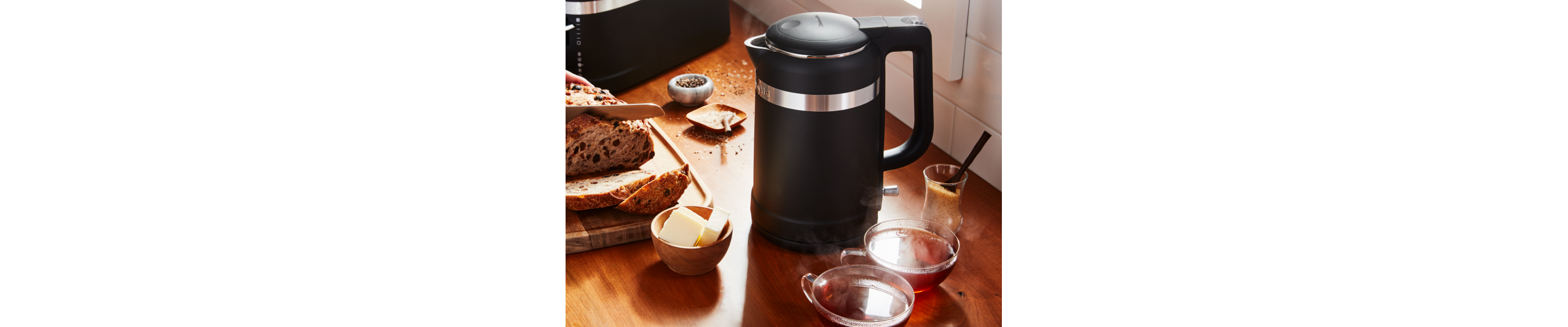 Black KitchenAid® electric kettle next to sliced bread and butter