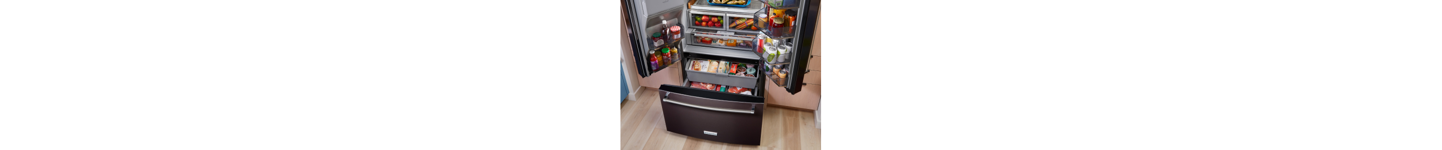 Stocked KitchenAid® refrigerator with doors and freezer drawer open