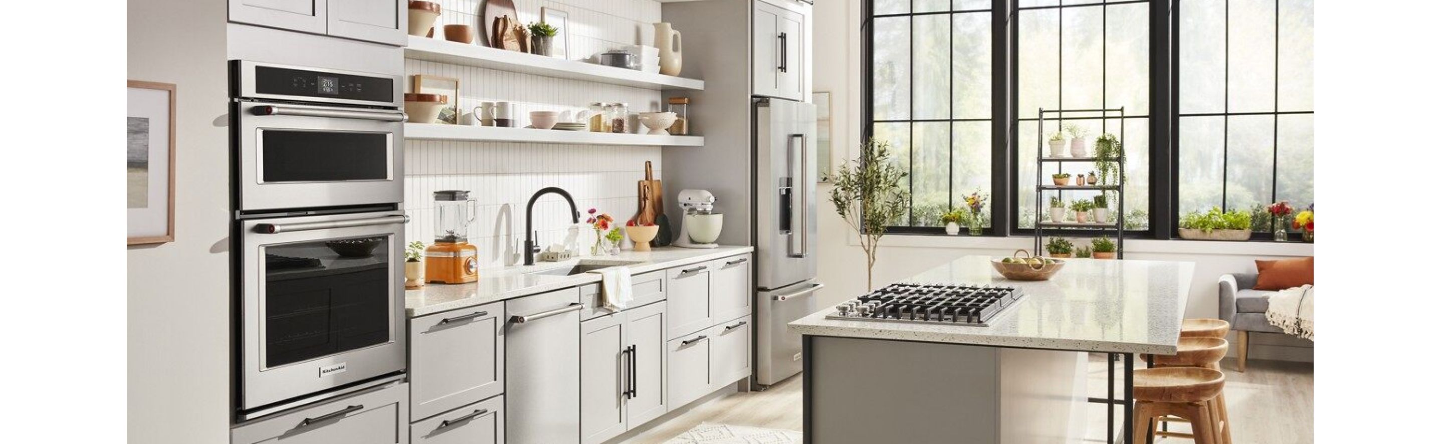 KitchenAid® appliances shown installed in a modern kitchen and bar area.