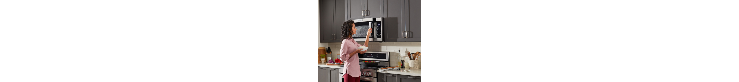 Person opening microwave with bowl in hand