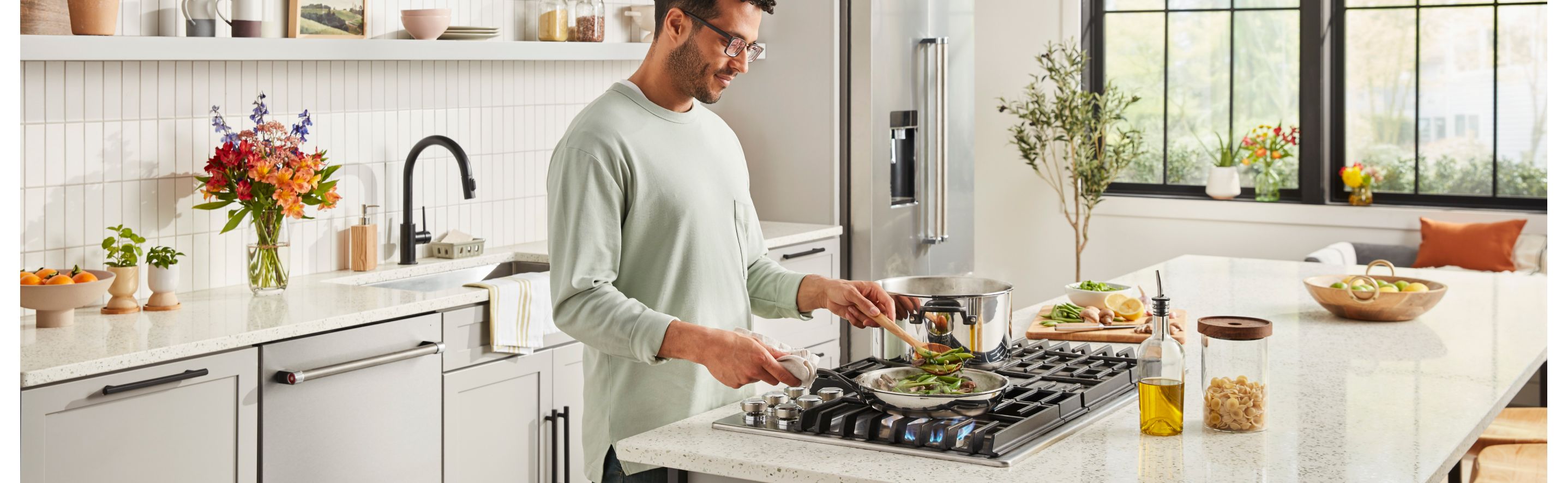 Person cooking vegetables on a kitchen island cooktop