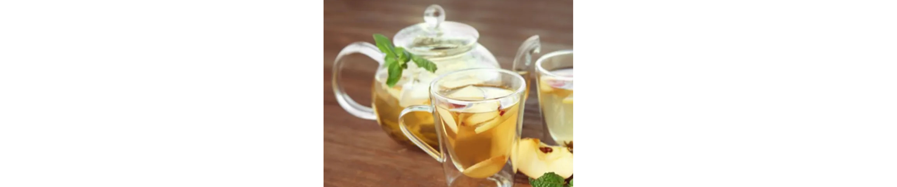 Sliced apples in a clear glass of tea.