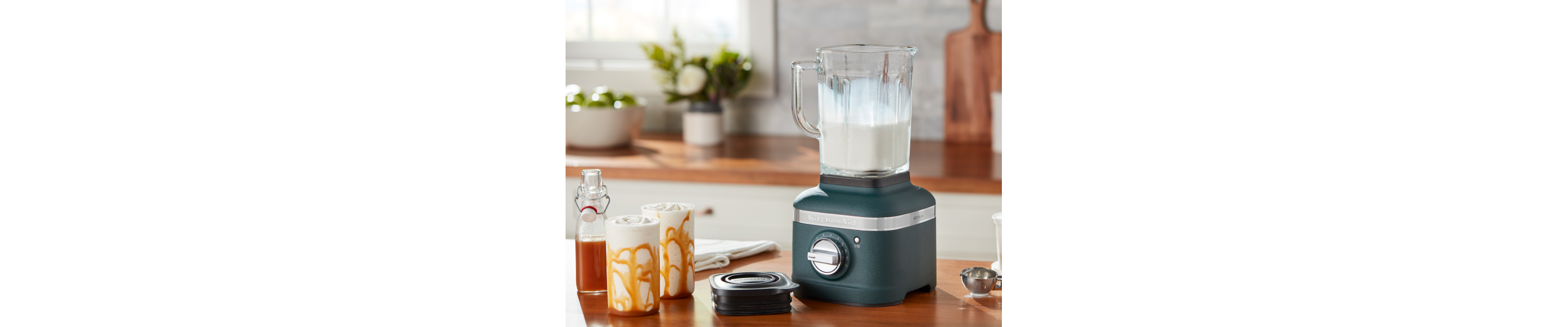 A KitchenAid® blender with milkshake ingredients on a modern kitchen counter.