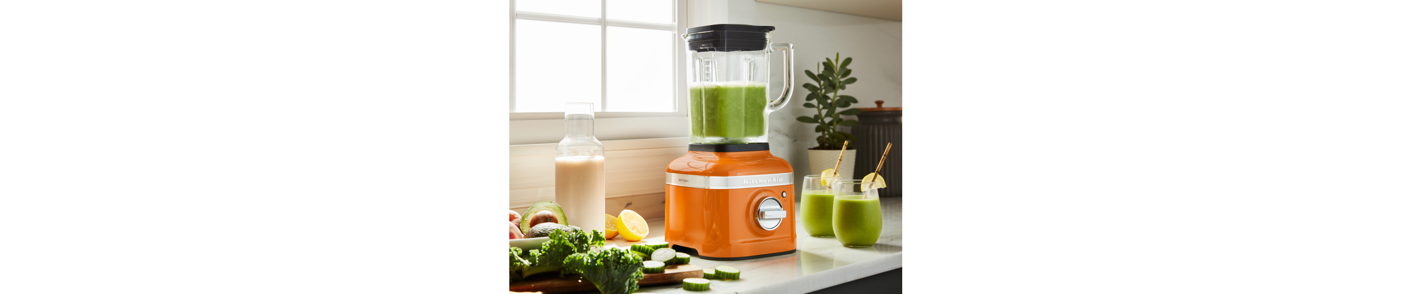 A KitchenAid® blender with freshly made juice on a modern kitchen counter.