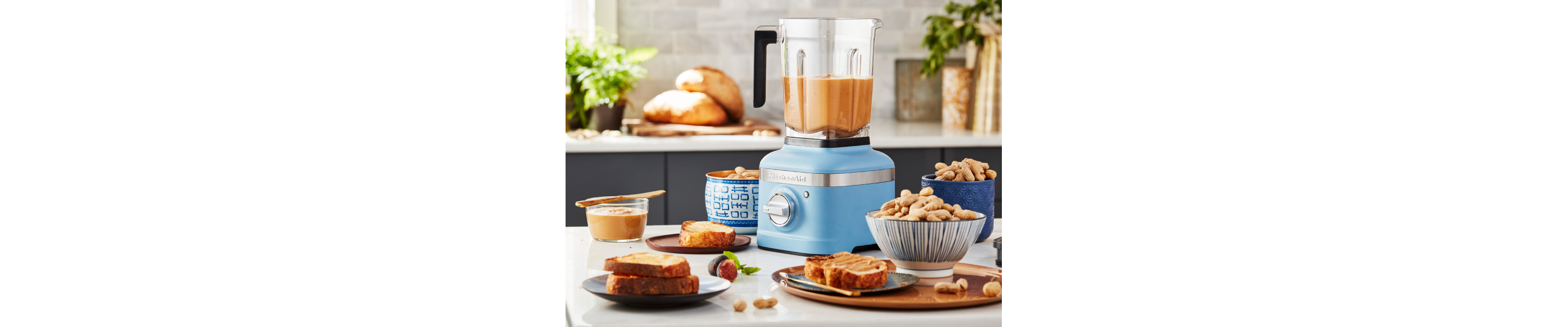 A KitchenAid® blender with blended nut butter on a modern kitchen counter.