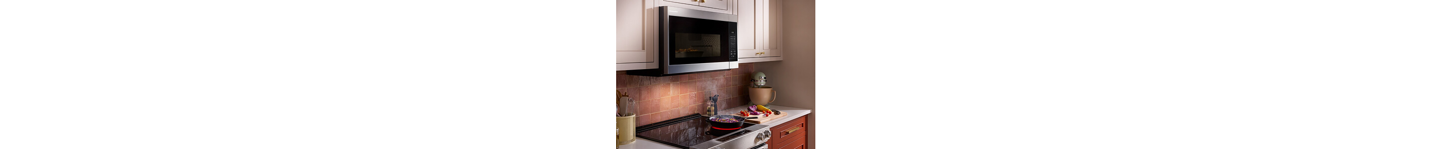 An over-the-range microwave built into cream upper cabinets