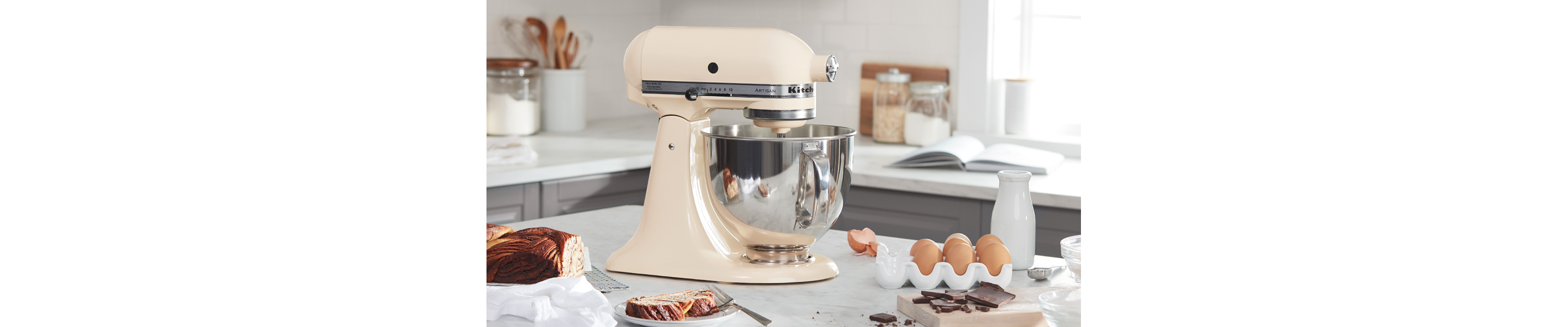 A beige KitchenAid® stand mixer next to baking ingredients.