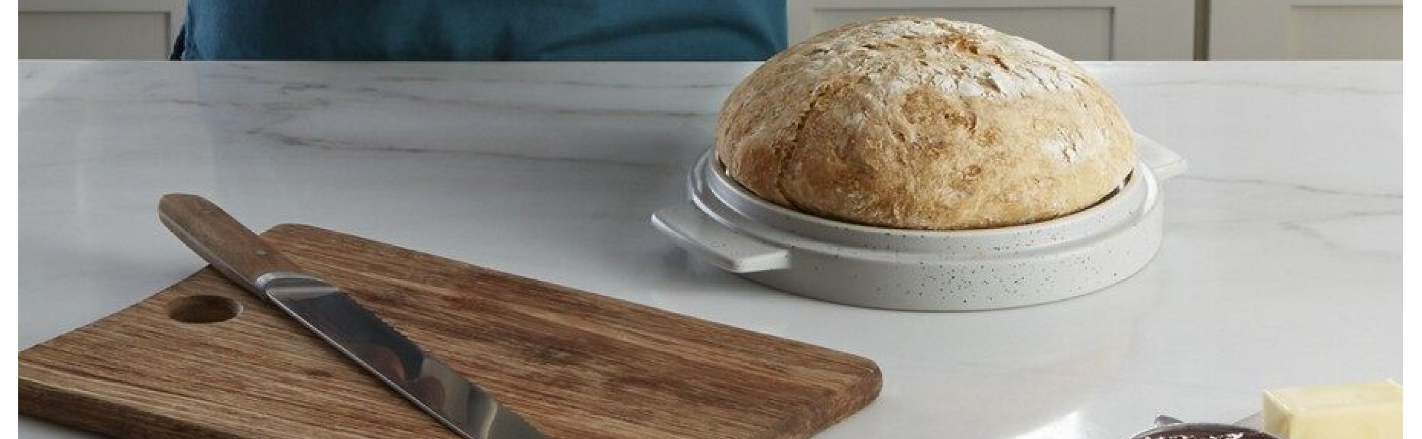 Loaf of bread next to a wooden cutting board and knife