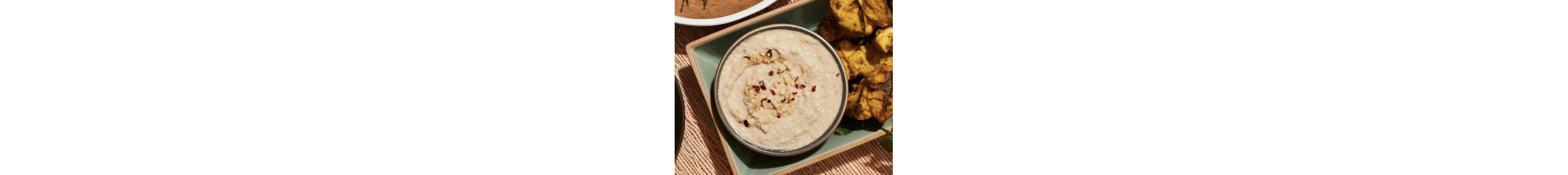 A bowl of peanut sauce with chopped nuts on top
