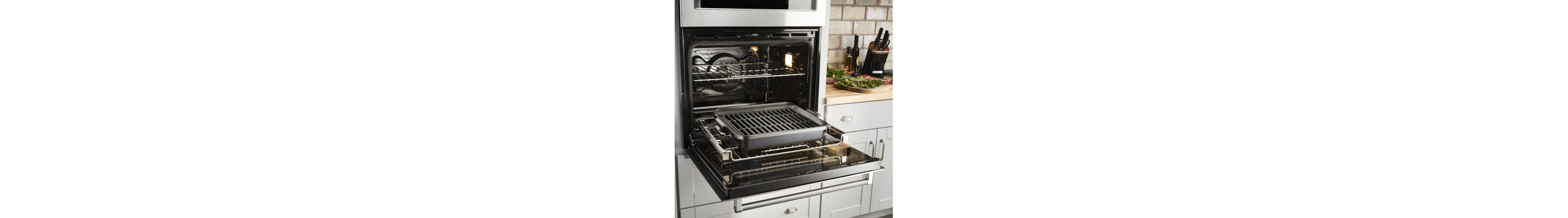 An open KitchenAid® oven with a grill pan