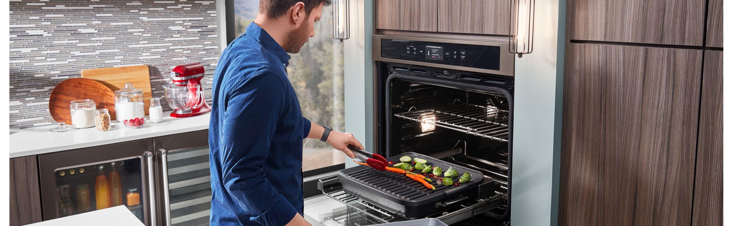 Person grilling vegetables in a KitchenAid® Smart Oven+