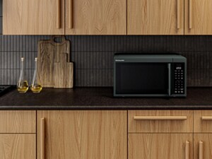 A dark colored KitchenAid® microwave blending in against dark countertops and backsplash