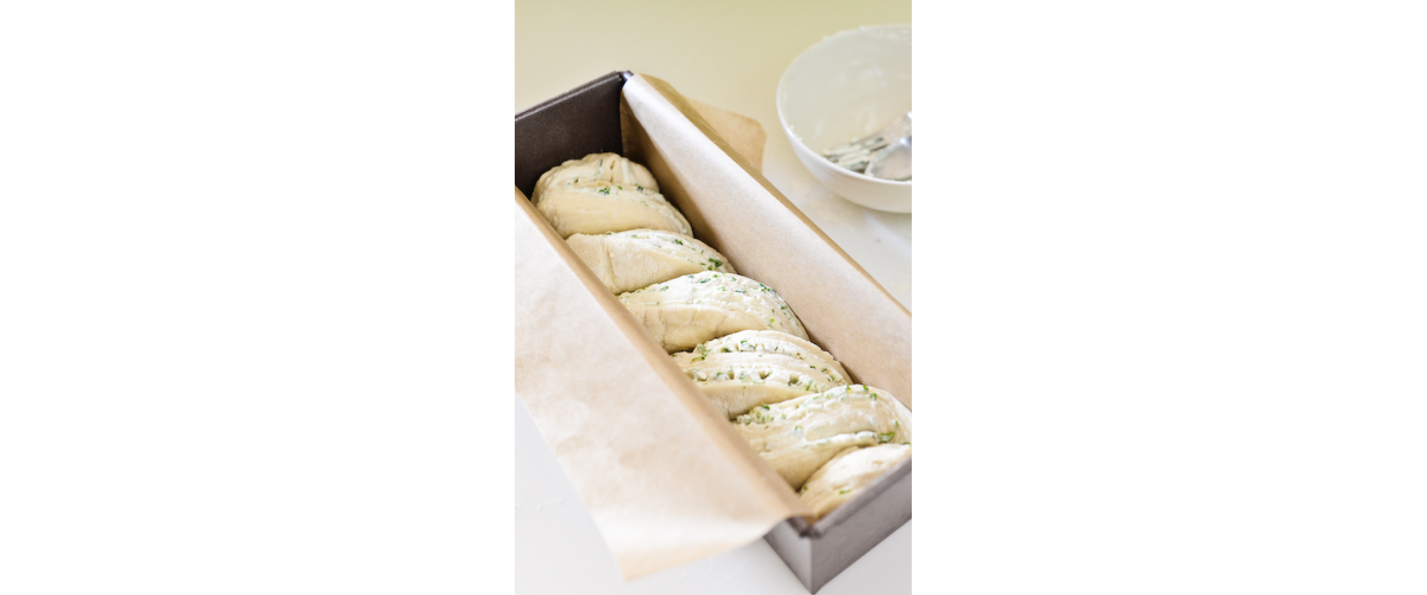 Braided babka resting in a prepared loaf pan