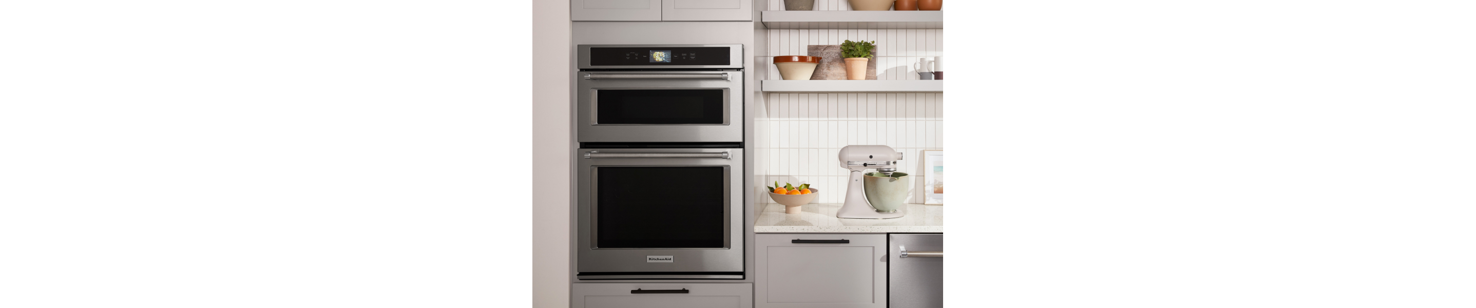 A KitchenAid® double oven next to a white stand mixer