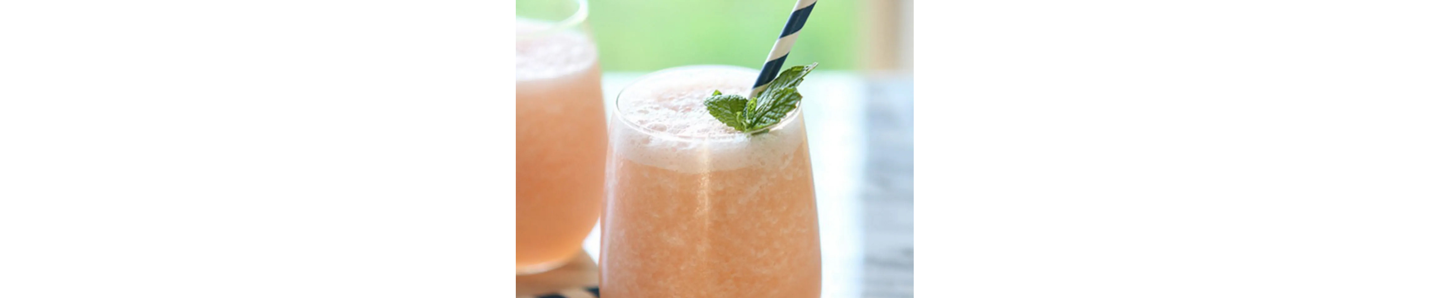 Frozen citrus cocktails with mint garnish and blue and white straws