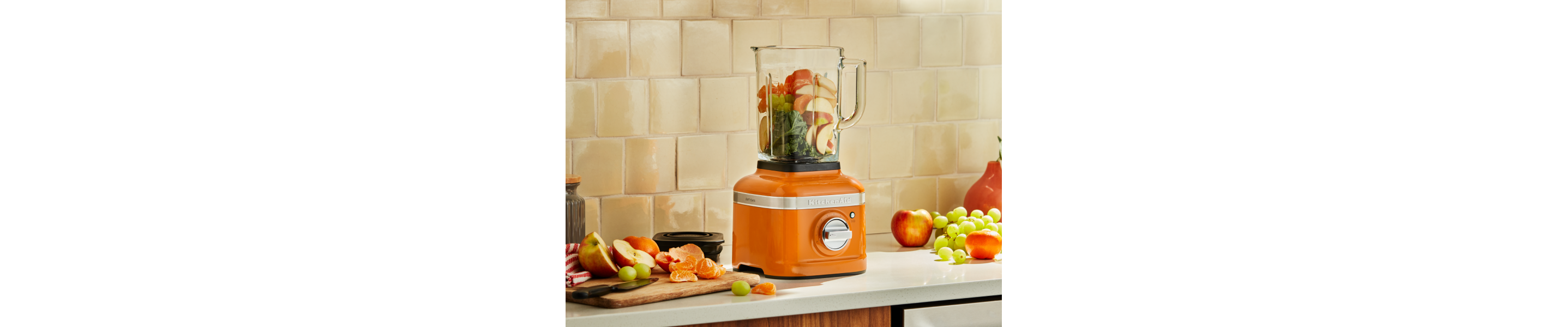 Orange KitchenAid® blender with produce inside