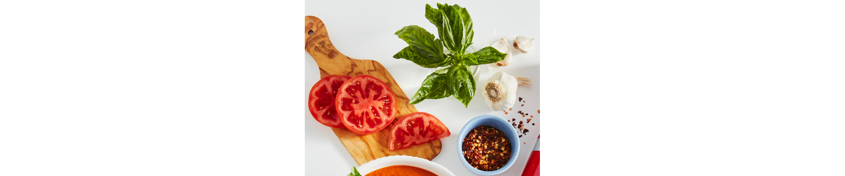 Bruschetta ingredients on a cutting board on a counter.