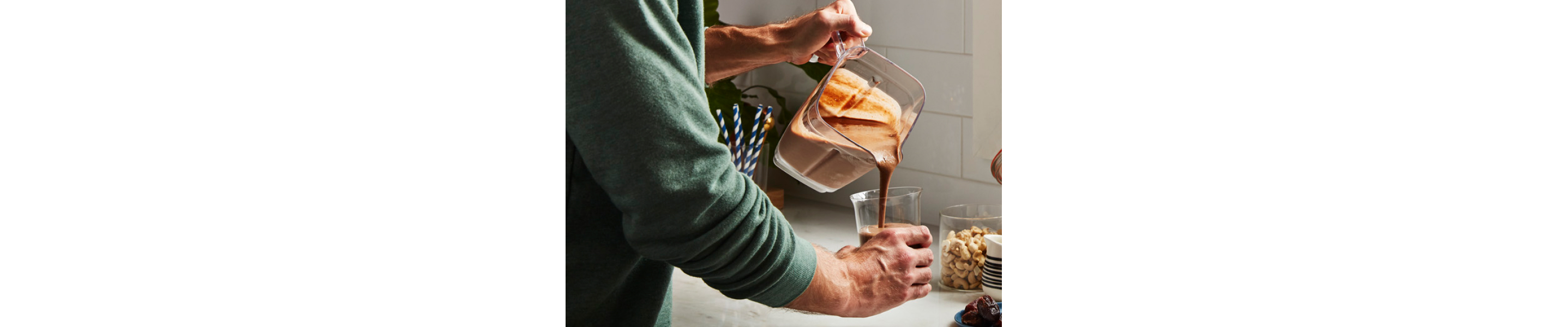 Person pouring protein shake into a glass