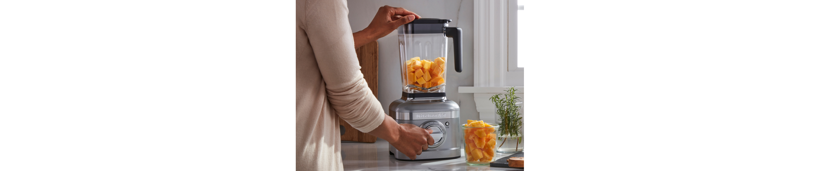 Person blending pumpkin in a KitchenAid® blender