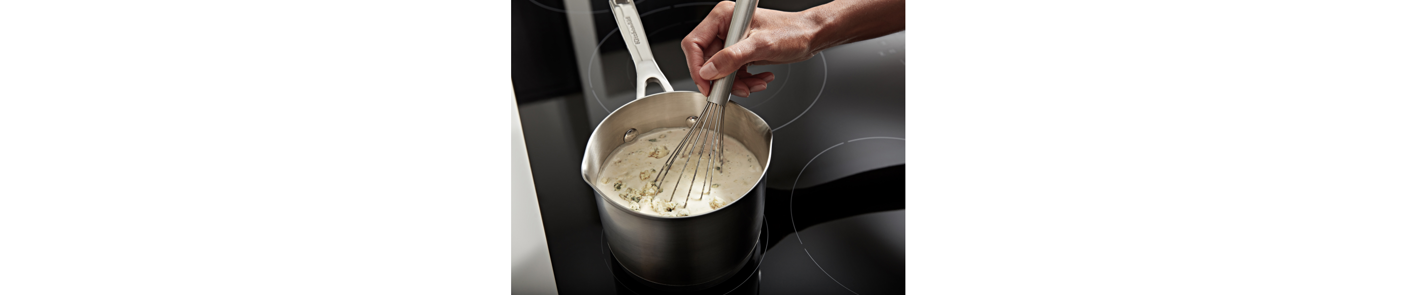 A hand whisking rice and heavy cream