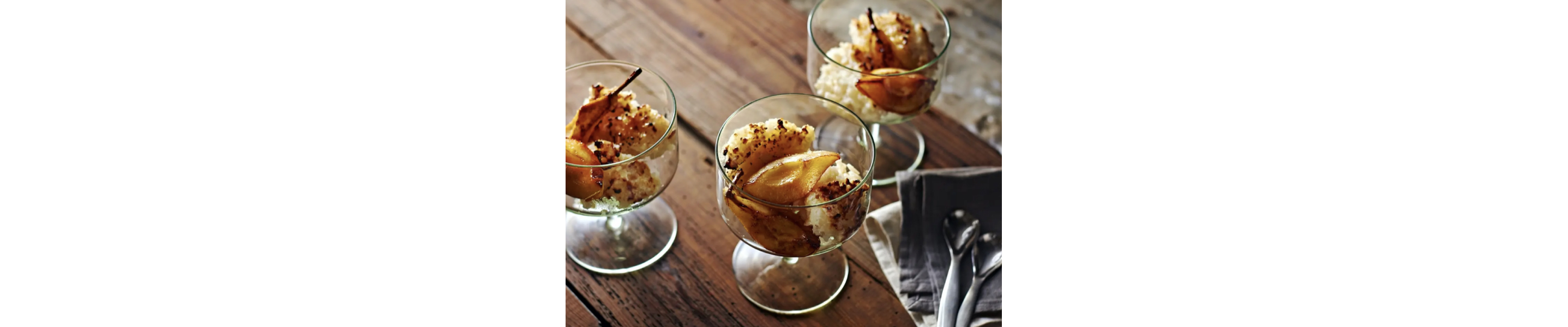 Rice pudding with caramelized pears in glass dessert bowls. 