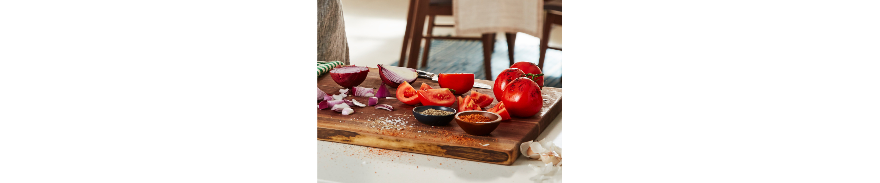 Sliced tomatoes and red onion on a cutting board