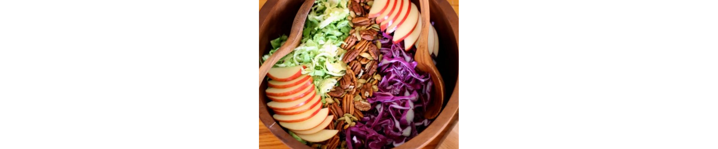 Salad bowl filled with chopped fruits, vegetables and nuts