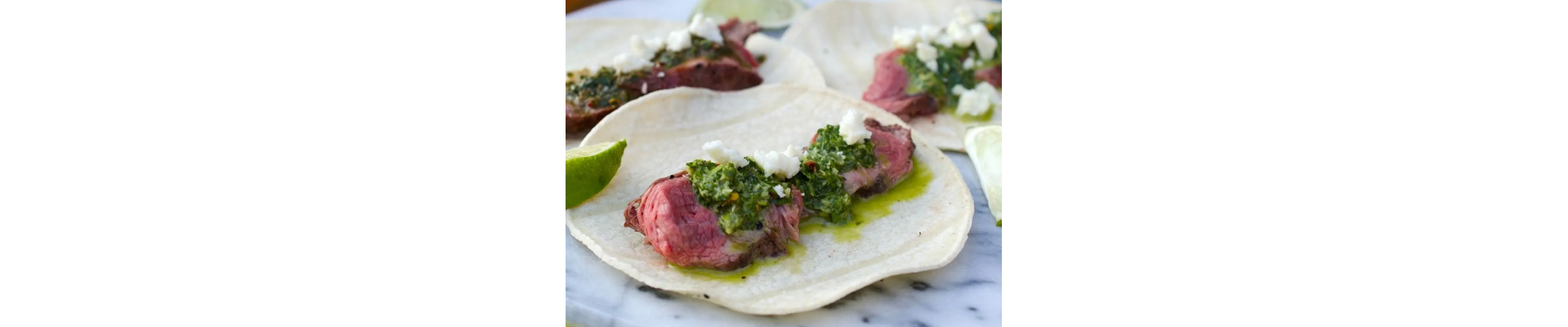 Steak tacos topped with chimichurri