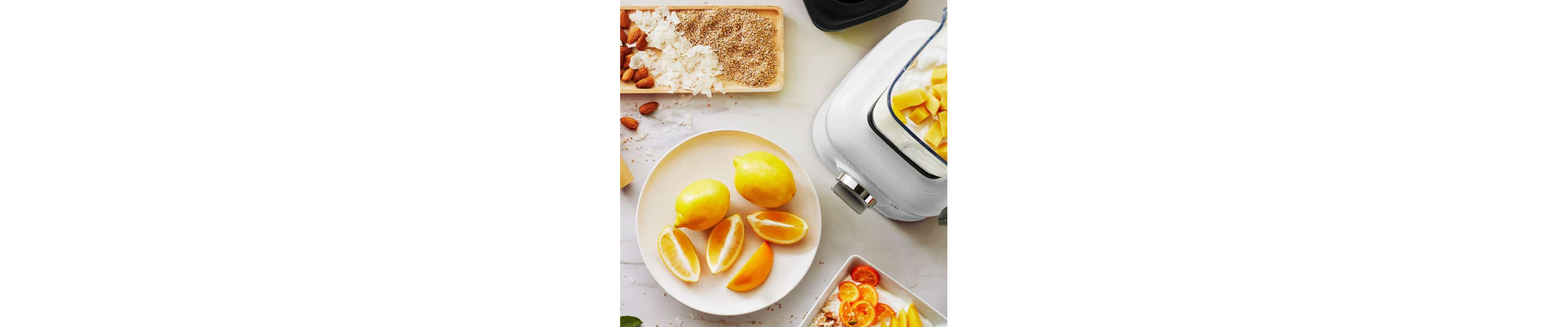 Sliced citrus on a plate next to a KitchenAid® blender