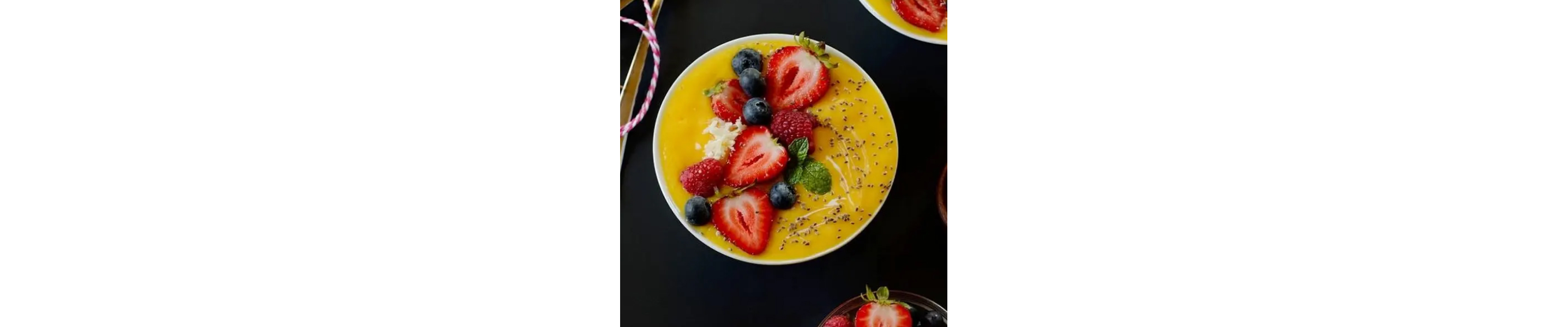 Mango smoothie bowl topped with sliced berries