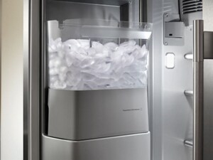A full ice maker in the door of a refrigerator
