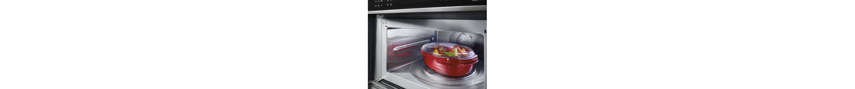 Covered bowl of vegetables in a microwave
