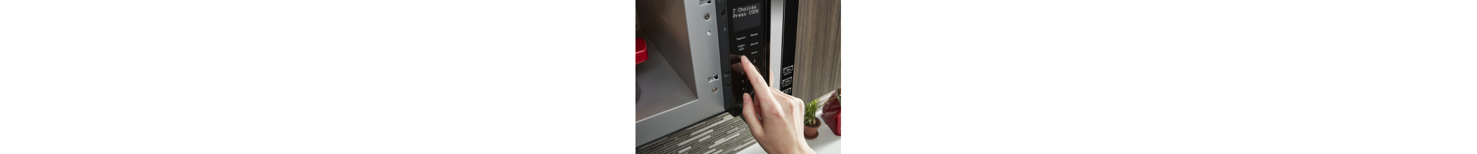 Person pushing button on a microwave