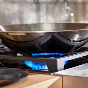A close-up of cookware on a lit gas burner
