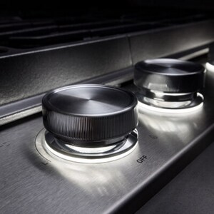 A close-up image of the knobs on a gas stovetop