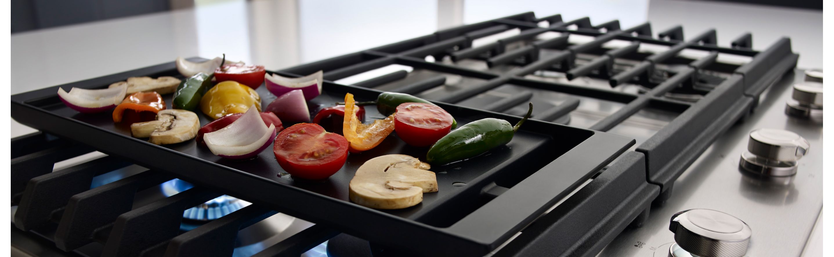Vegetables cooking on a gas stove griddle