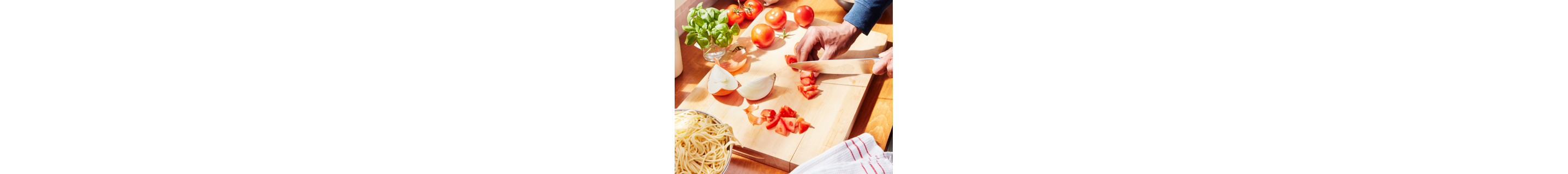 Person chopping tomatoes on a cutting board