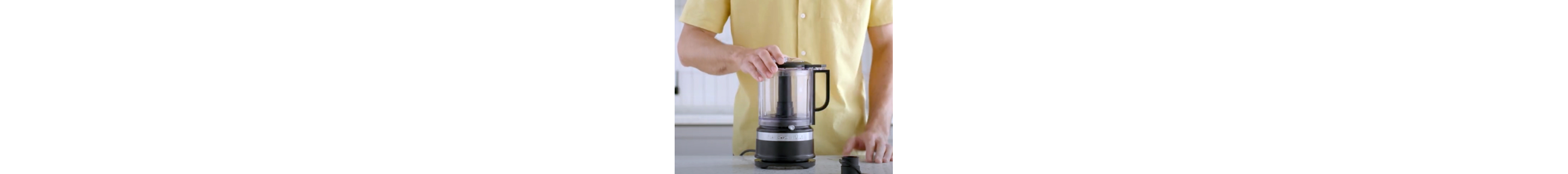 Person placing lid on black food chopper