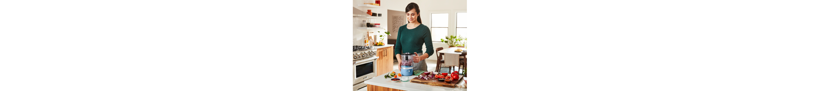 Person pulsing red onions in a blue food chopper