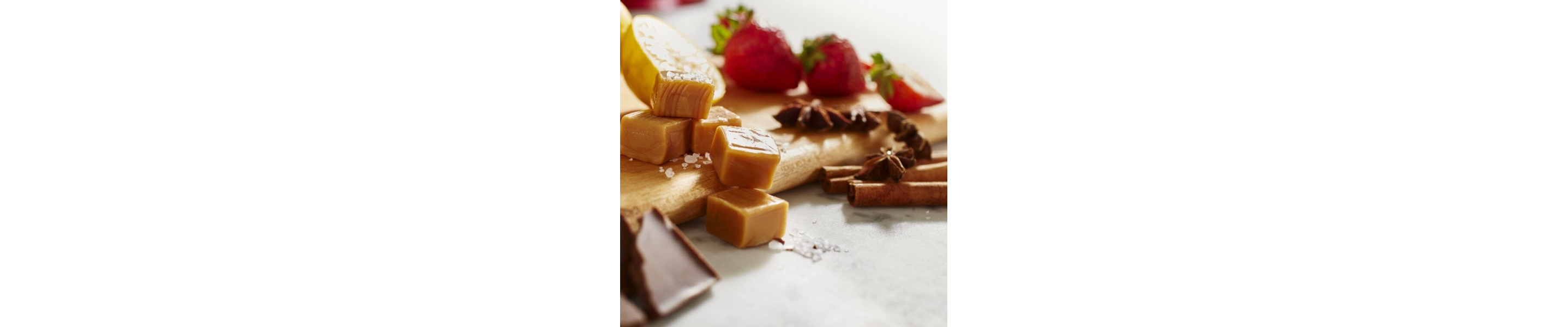 Caramel, chocolate and strawberries on a cutting board